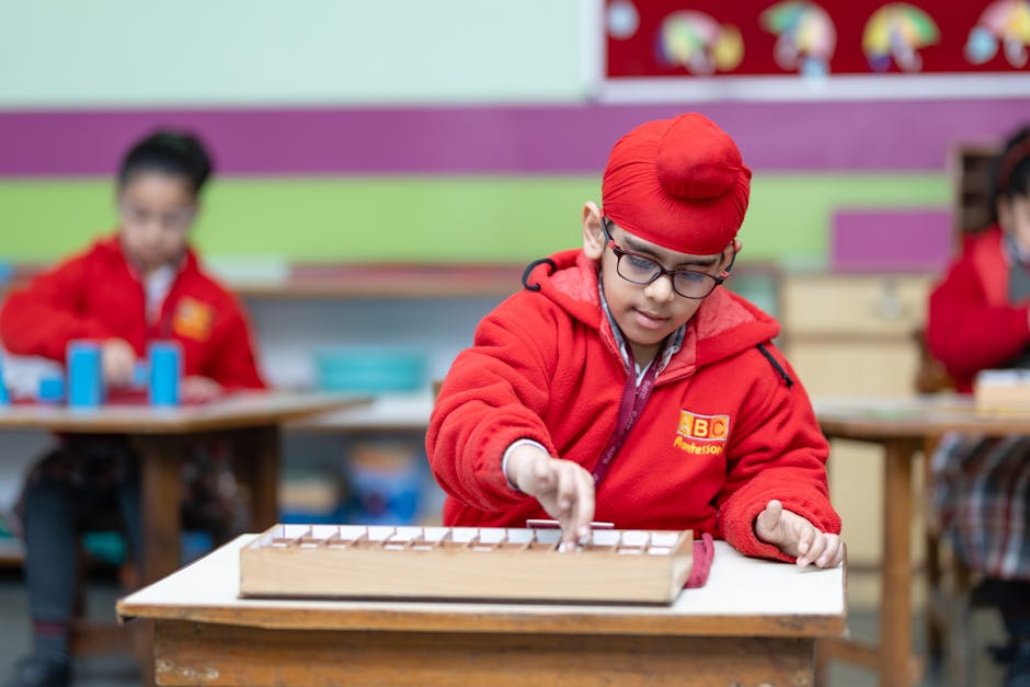 Young boy wearing glasses focused on educational activity in classroom setting